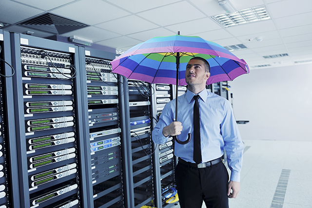 young handsome business man engineer in .businessman hold rainbow colored umbrella in server datacenter room and representing security and antivirus sofware protection concept